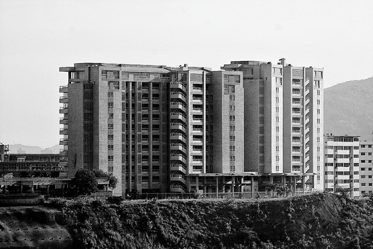 LOW ANGLE VIEW OF APARTMENT BUILDINGS AGAINST CLEAR SKY