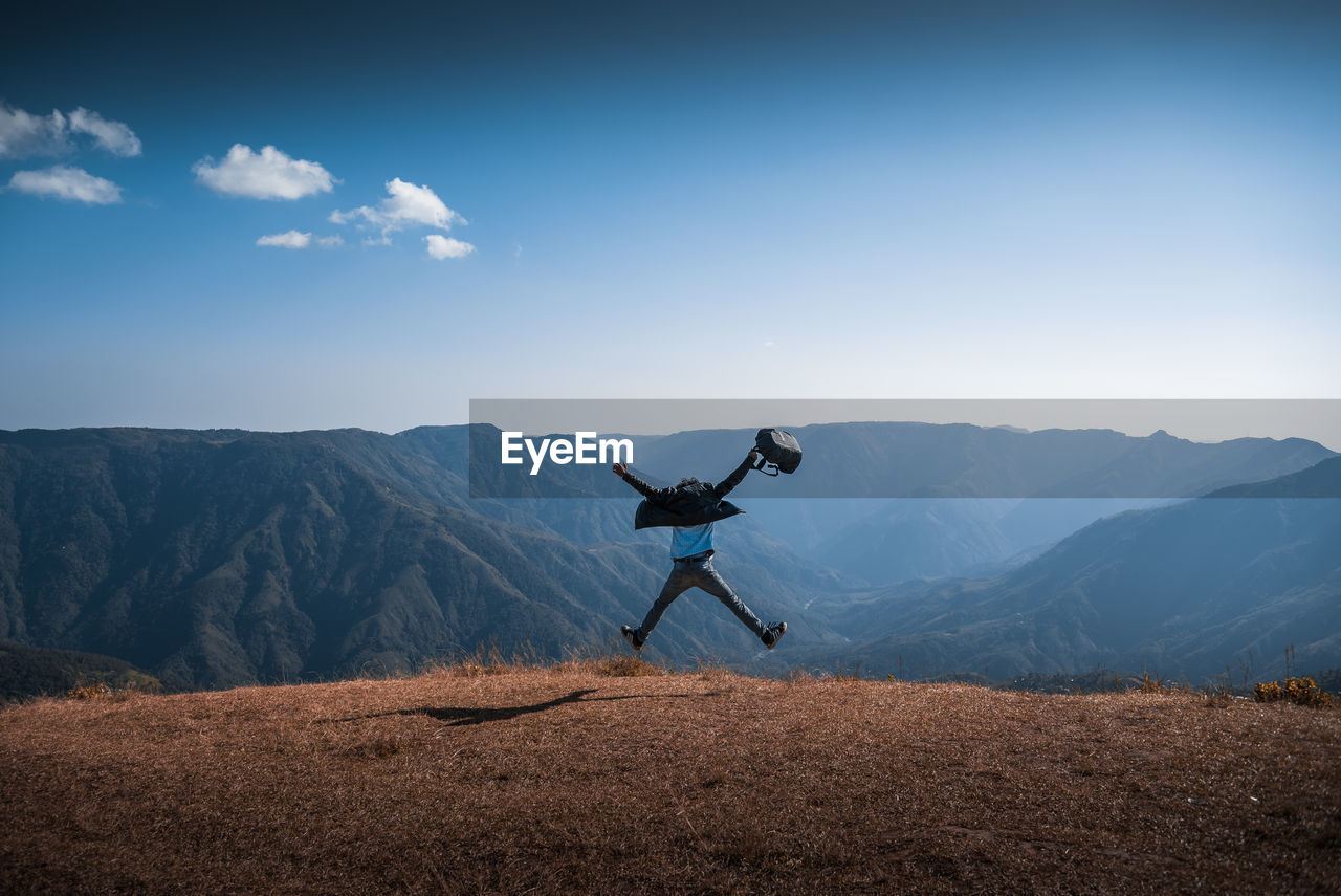 Man jumping against mountains