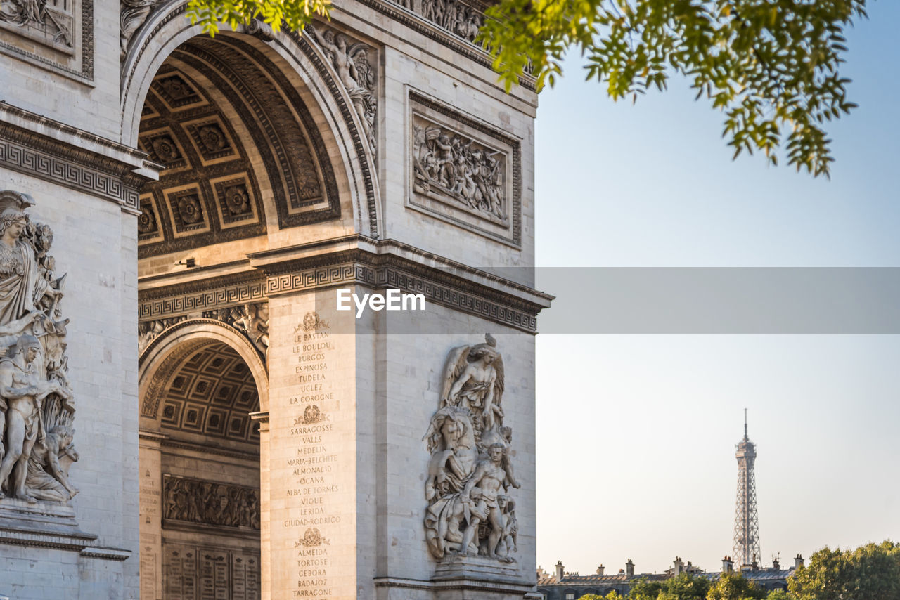 Close-up of the arch of triumph with the eiffel tower in the distance in paris france