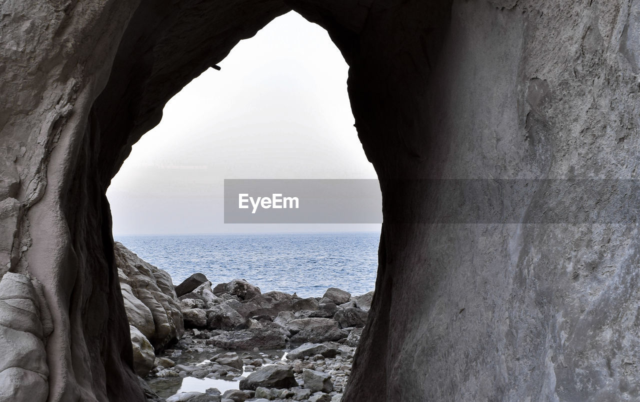 Scenic view of sea seen through cave