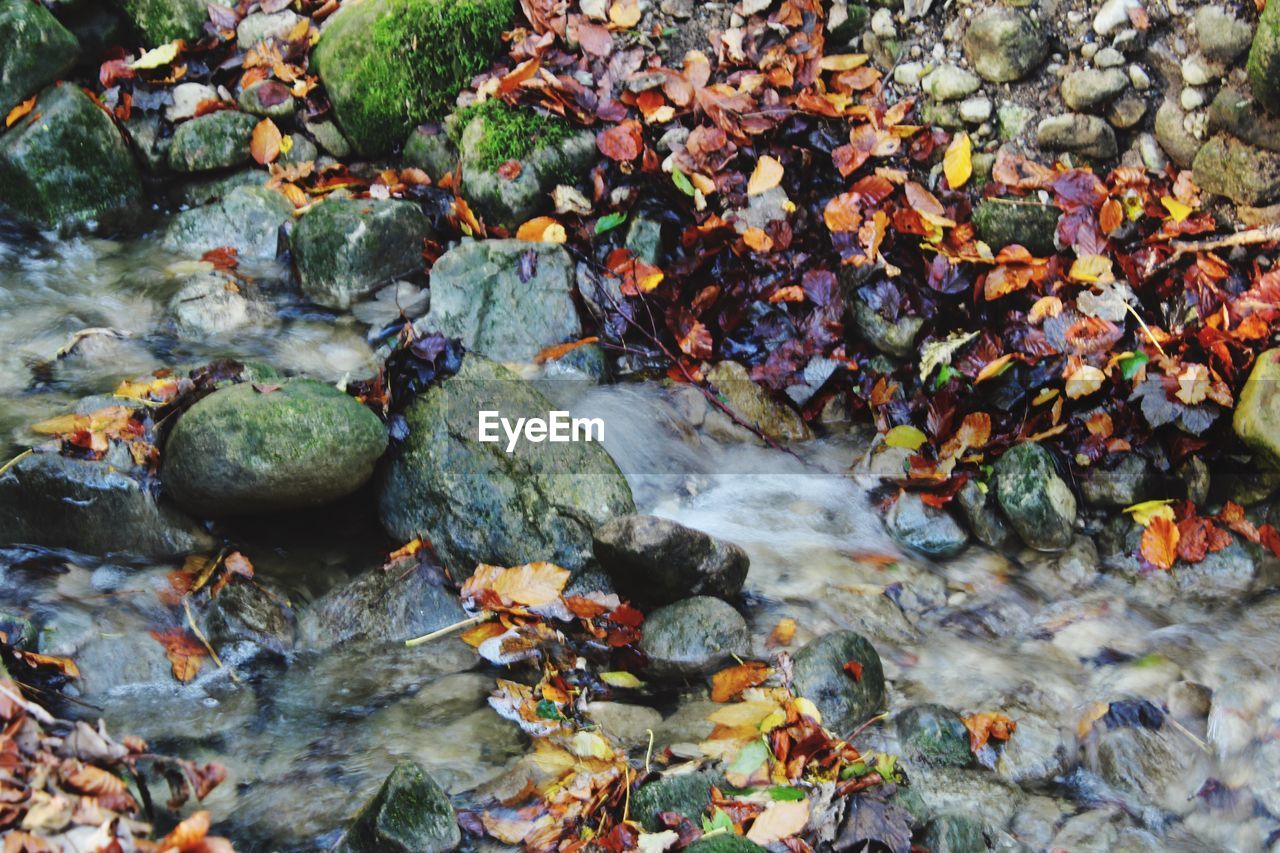 HIGH ANGLE VIEW OF WATERFALL AMIDST ROCKS