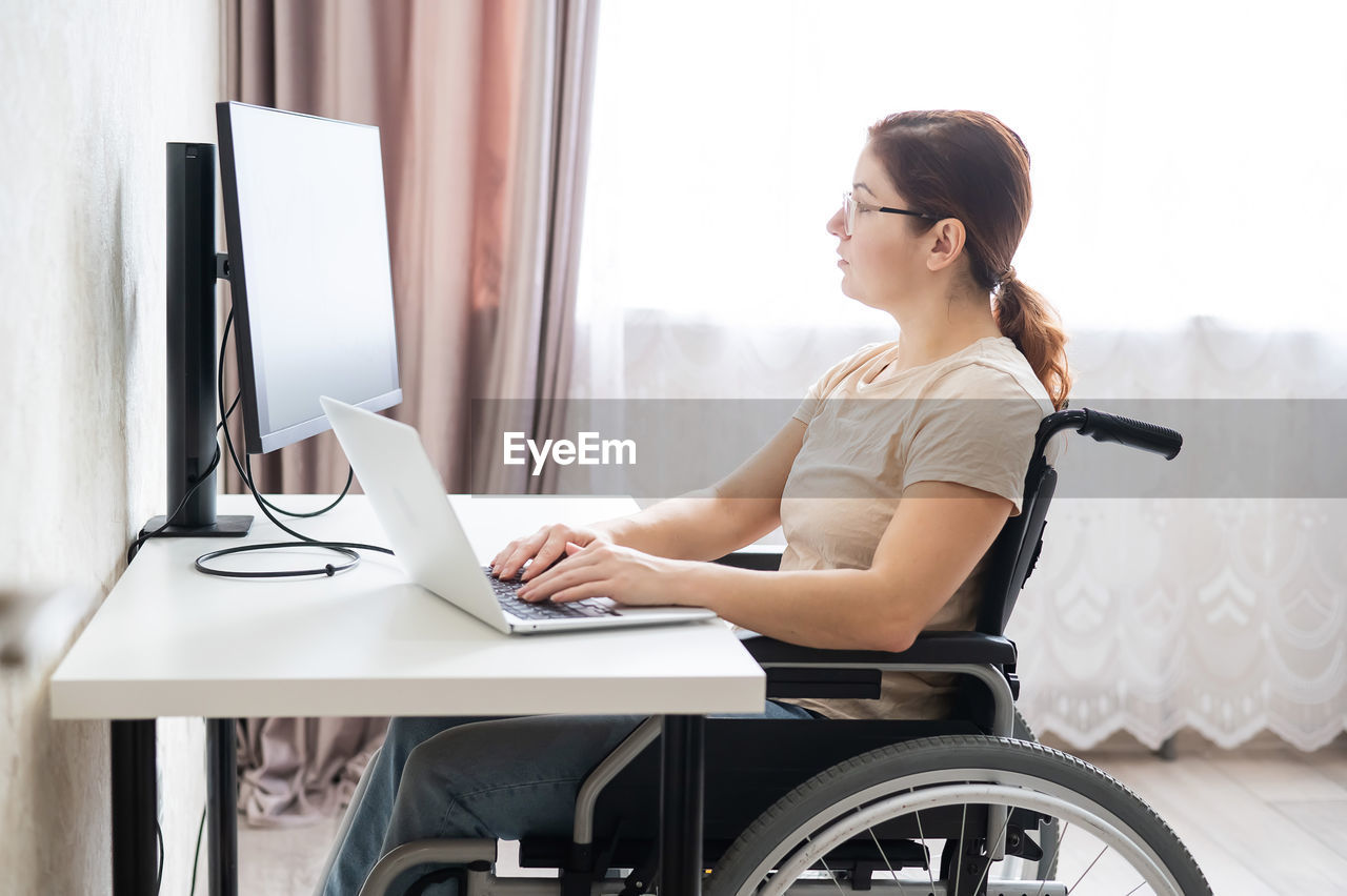 Disabled woman working on laptop at home