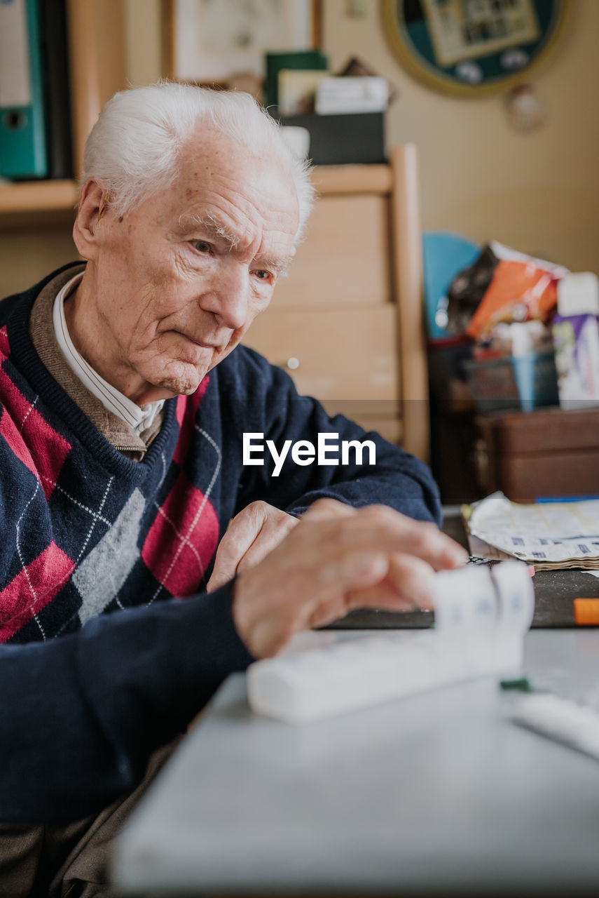 Senior man holding medicine at home