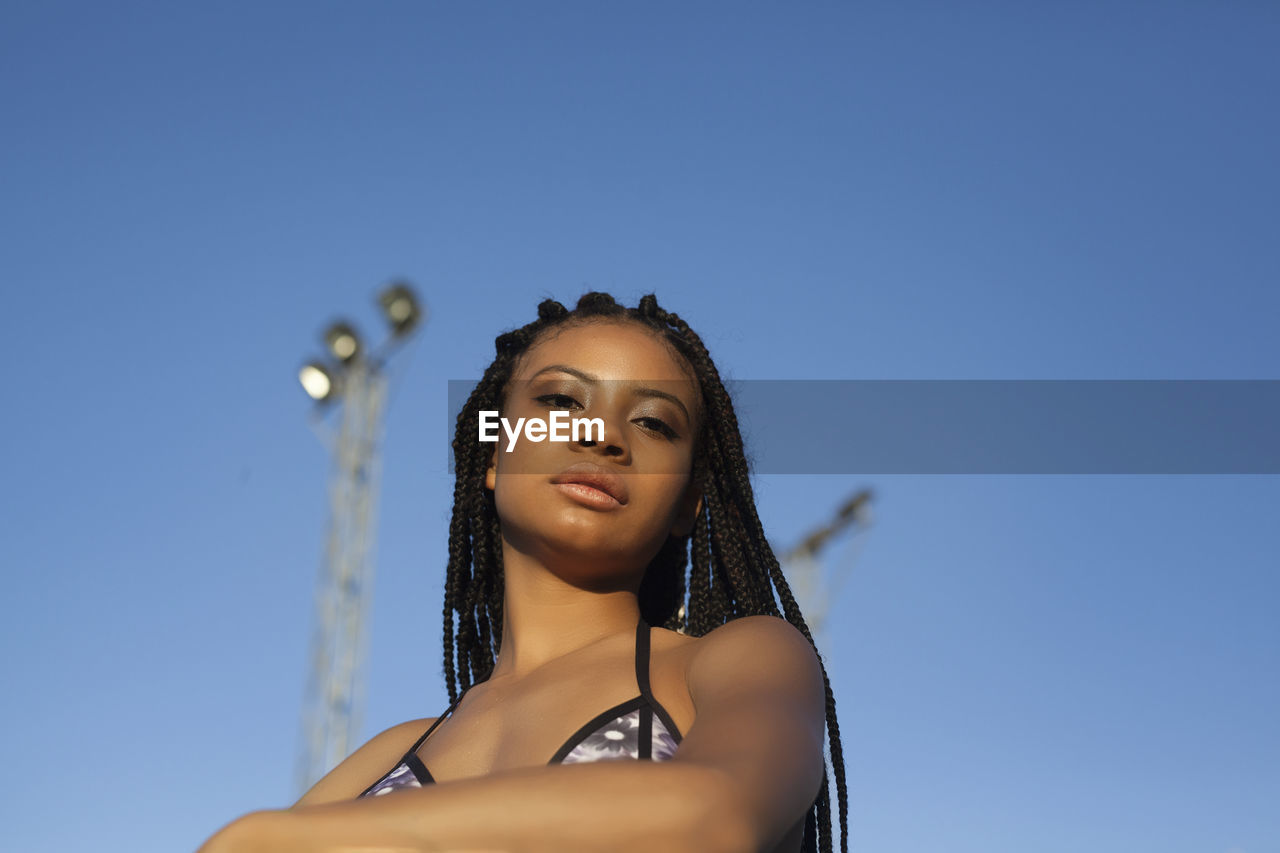 Portrait of a young african american woman with curly hair standing looking at camera