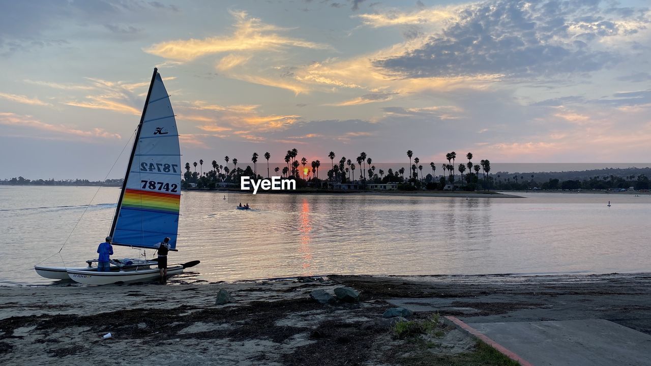 SAILBOAT ON SEA AGAINST SKY DURING SUNSET