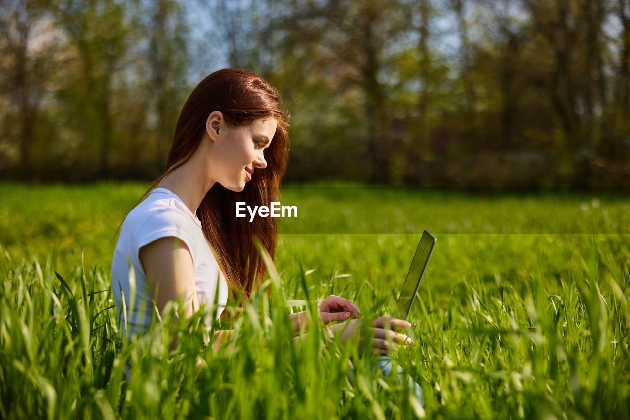 side view of young woman standing on field