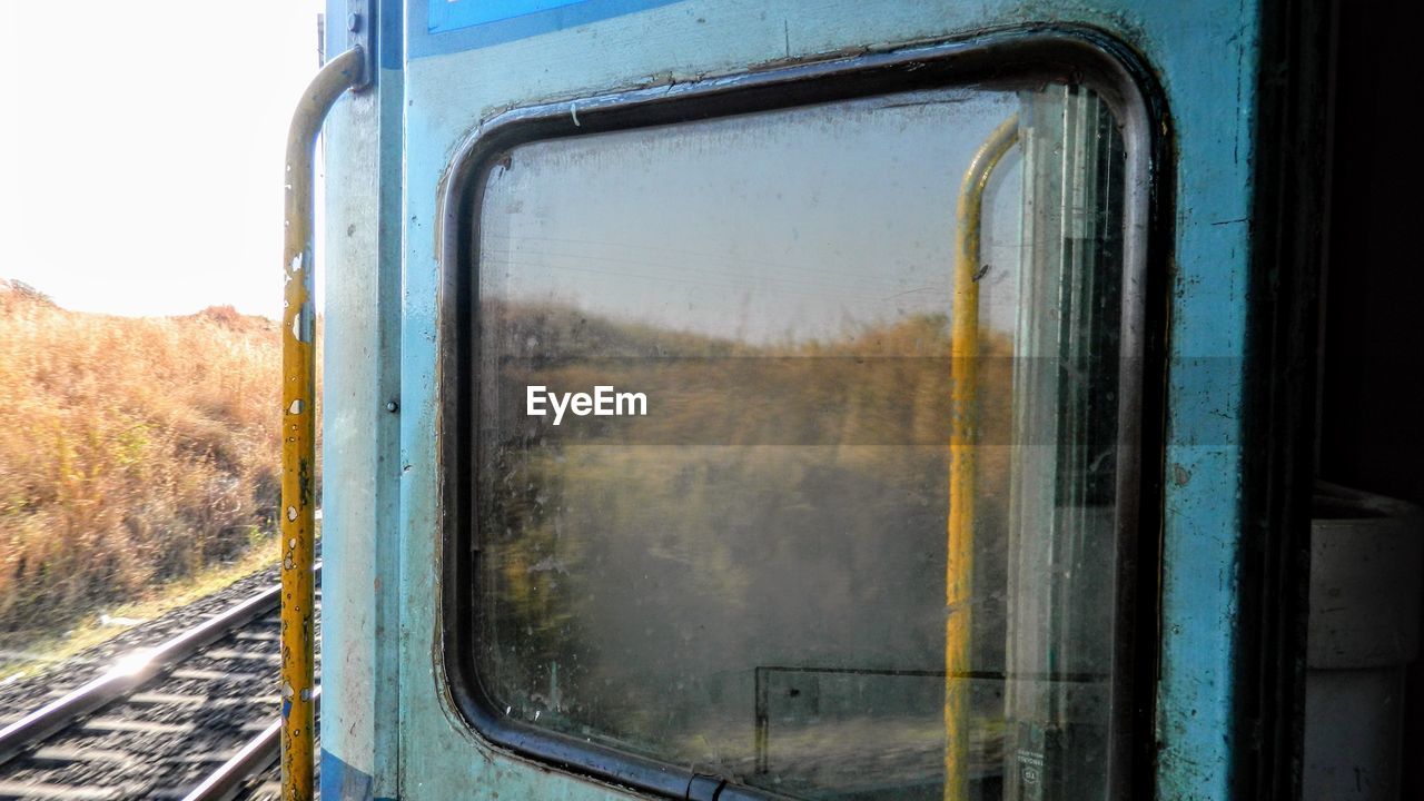 CLOSE-UP OF TRAIN SEEN THROUGH WINDOW OF BUS