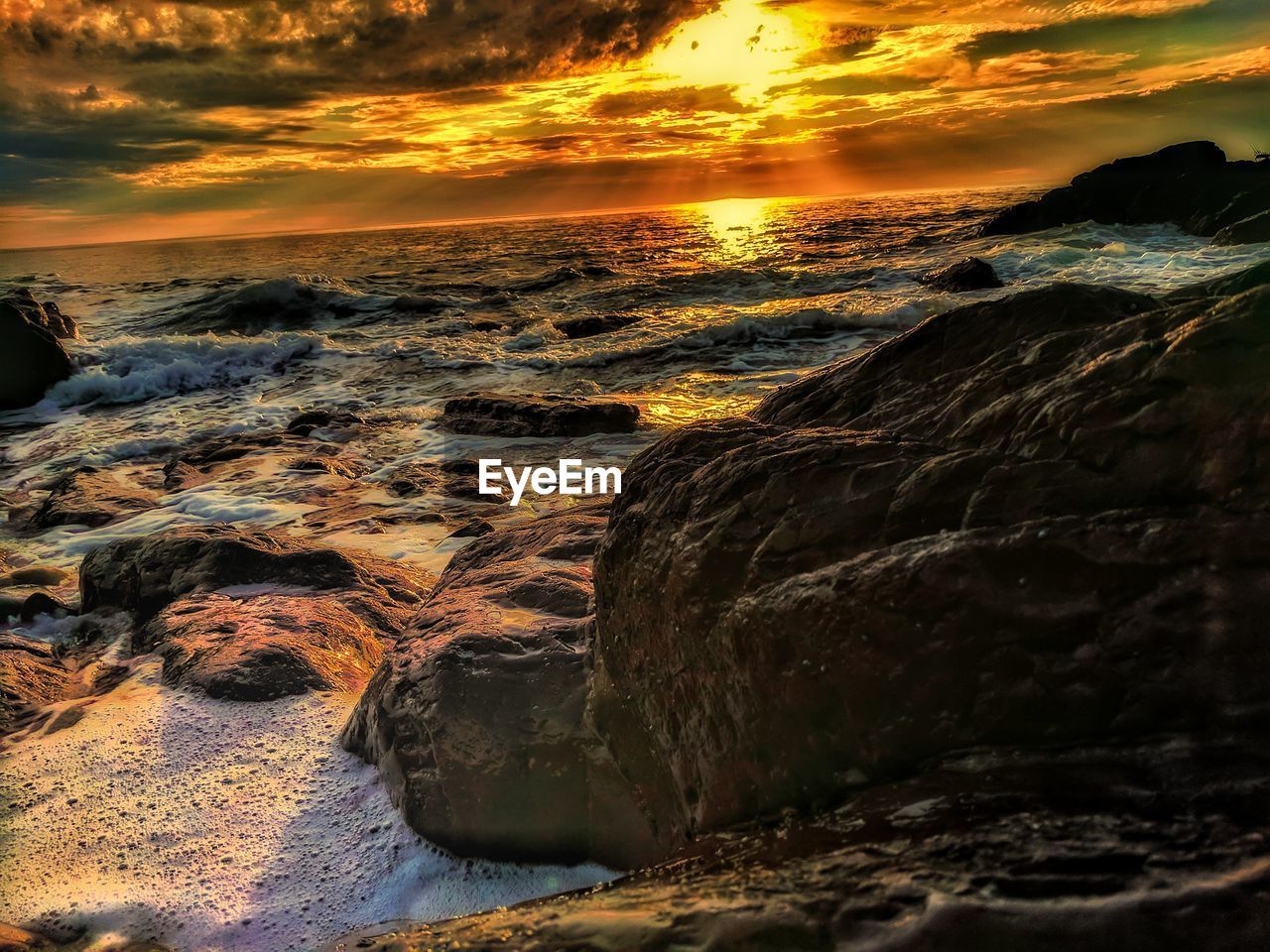 SCENIC VIEW OF BEACH AGAINST SKY AT SUNSET