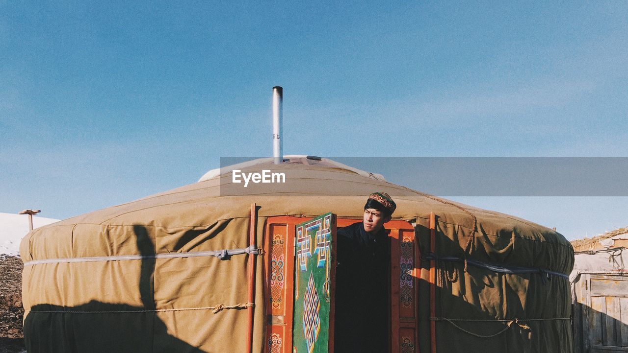 View of man in doorway of yurt