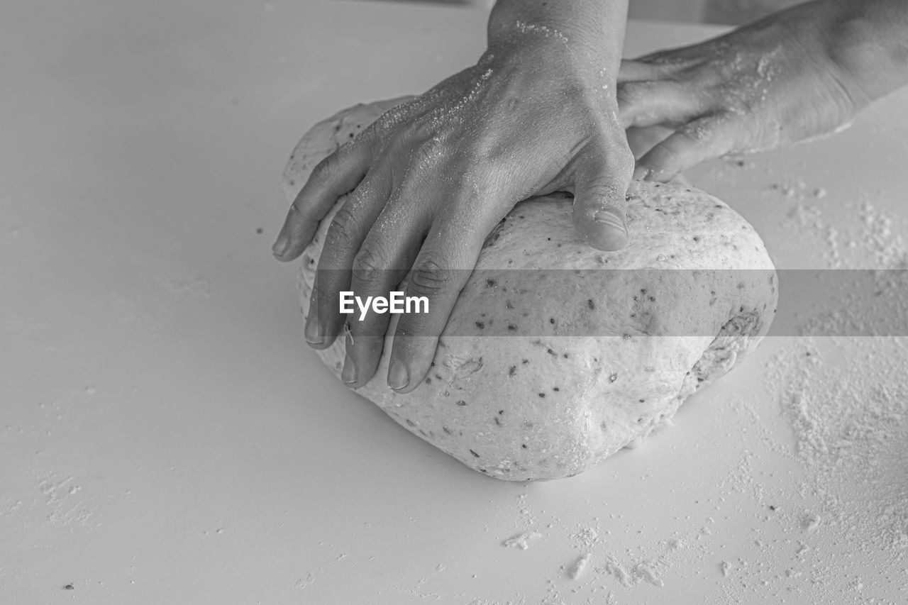 CLOSE-UP OF HAND HOLDING BREAD