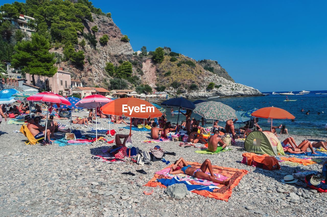 VIEW OF BEACH UMBRELLAS ON SEA SHORE AGAINST CLEAR SKY