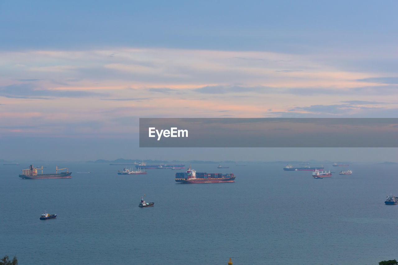 BOATS ON SEA AGAINST SKY DURING SUNSET