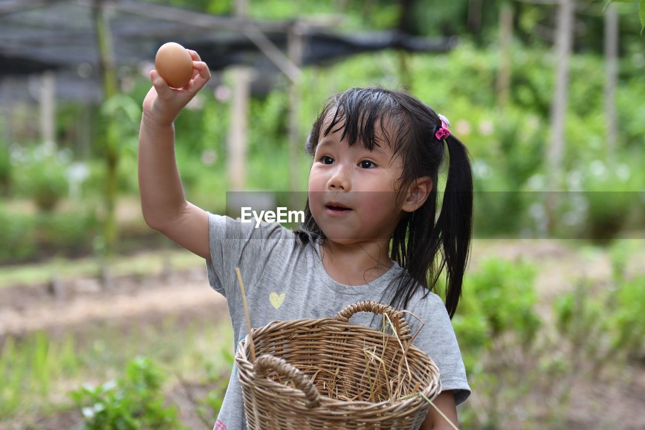 Smiling girl holding egg and wicker basket