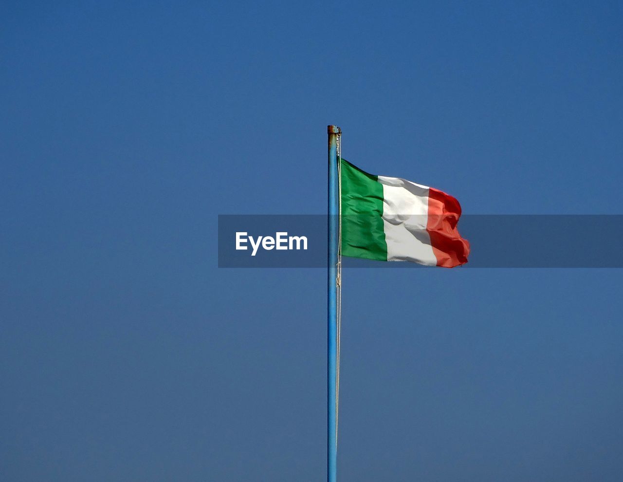 LOW ANGLE VIEW OF FLAG FLAGS AGAINST CLEAR BLUE SKY