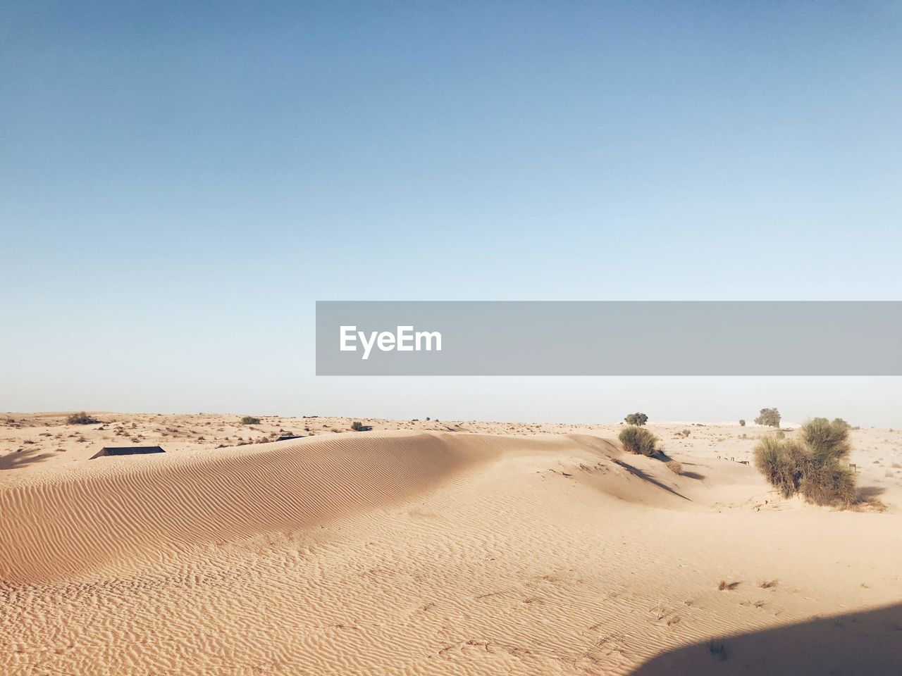 SAND DUNES IN DESERT AGAINST CLEAR SKY