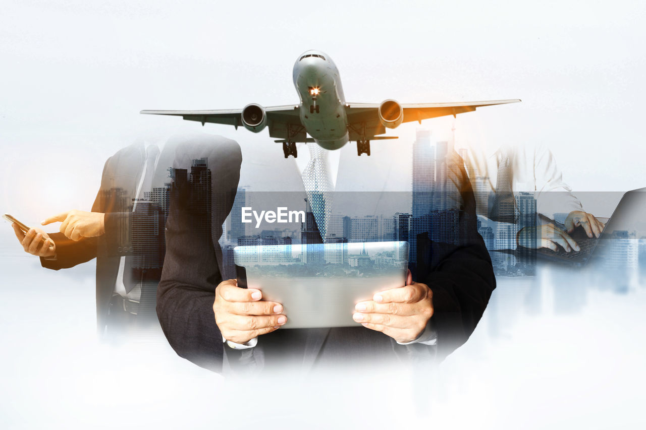 DIGITAL COMPOSITE IMAGE OF MAN HOLDING AIRPLANE AT CAMERA