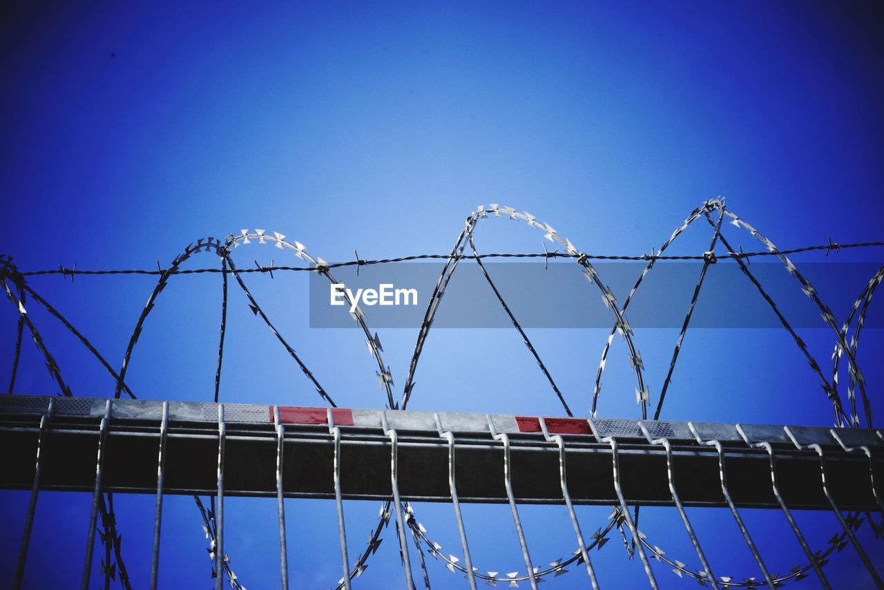 LOW ANGLE VIEW OF FENCE AGAINST BLUE SKY