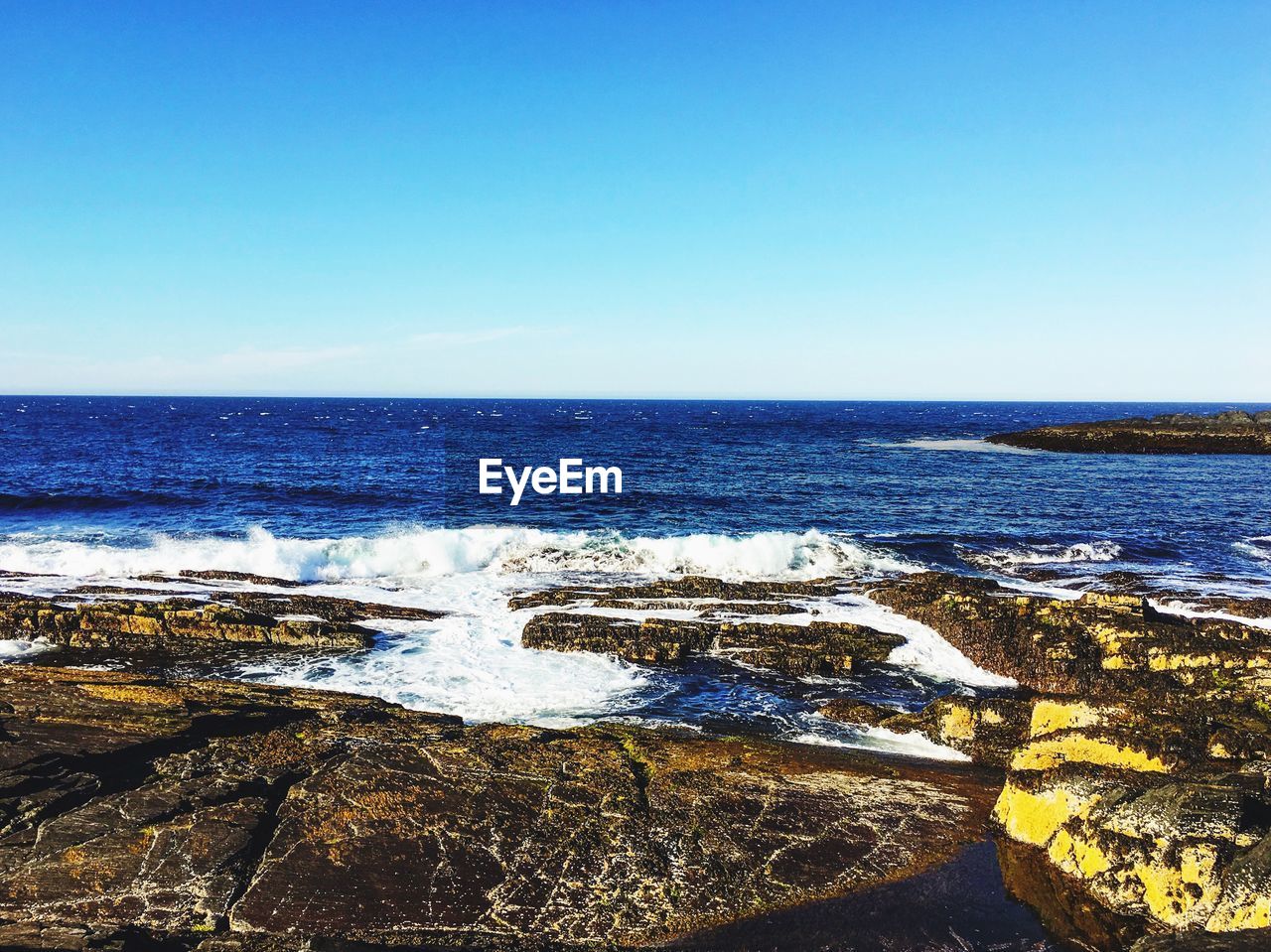 Scenic view of sea against clear blue sky