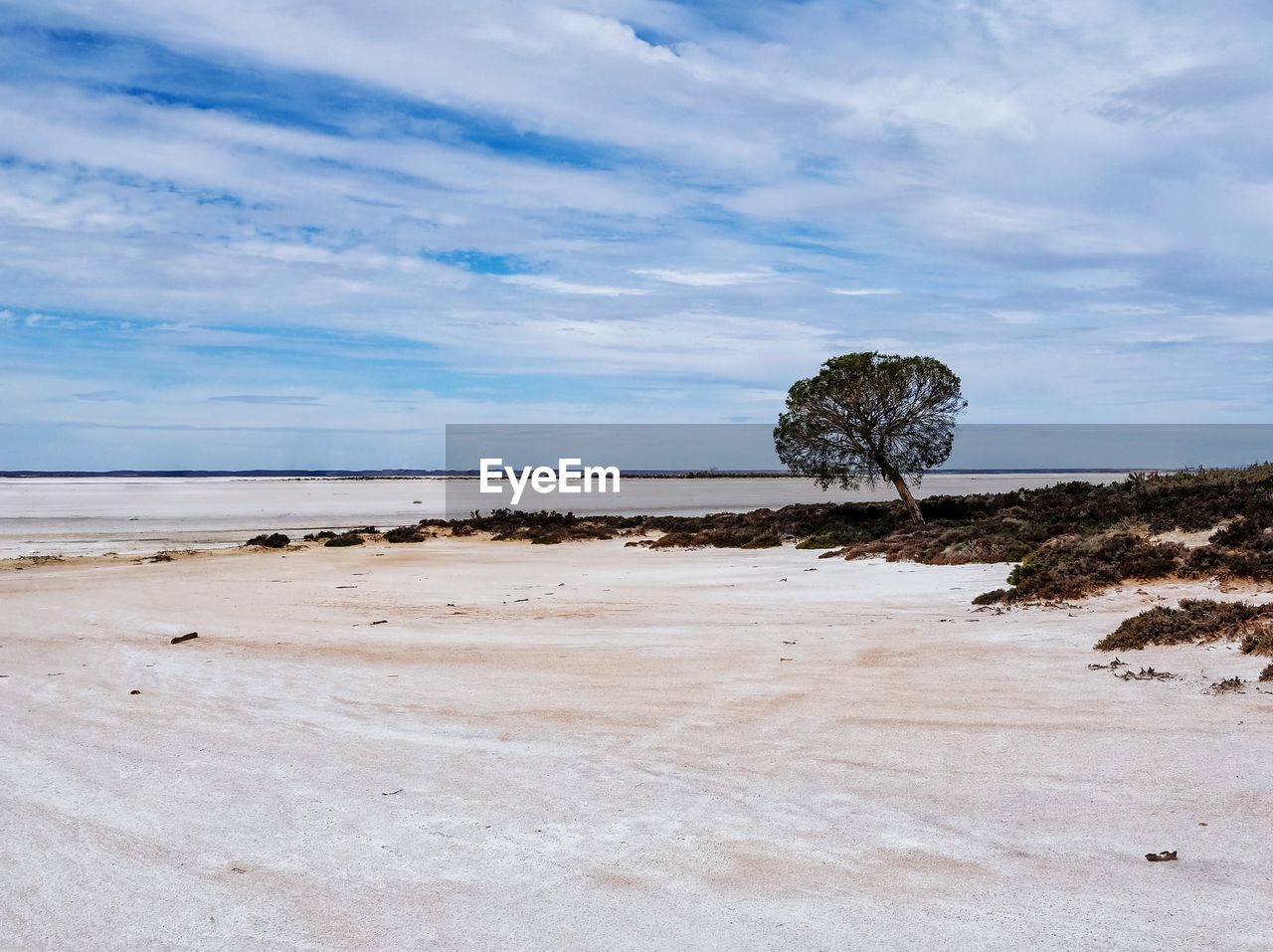 Scenic view of vast arid land against sky