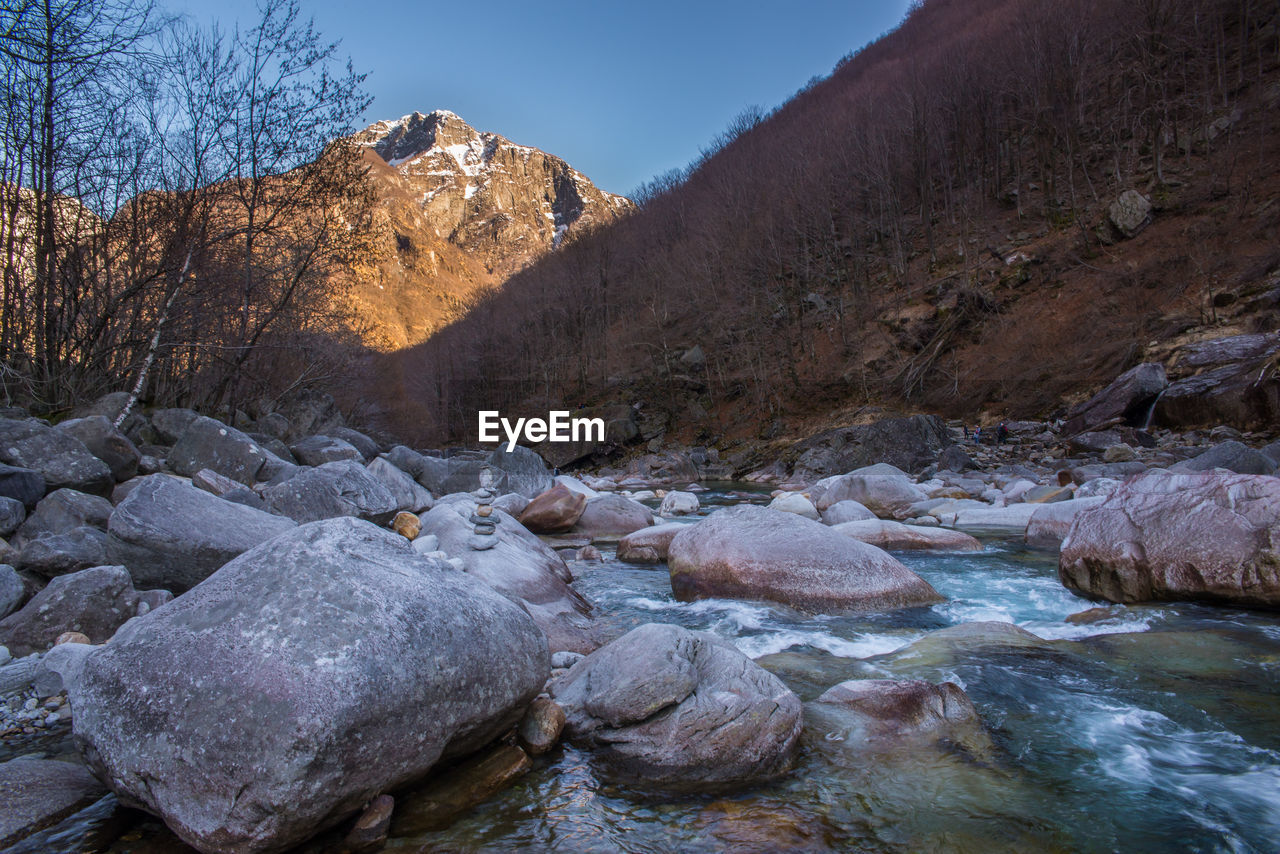 Scenic view of river by mountains against sky