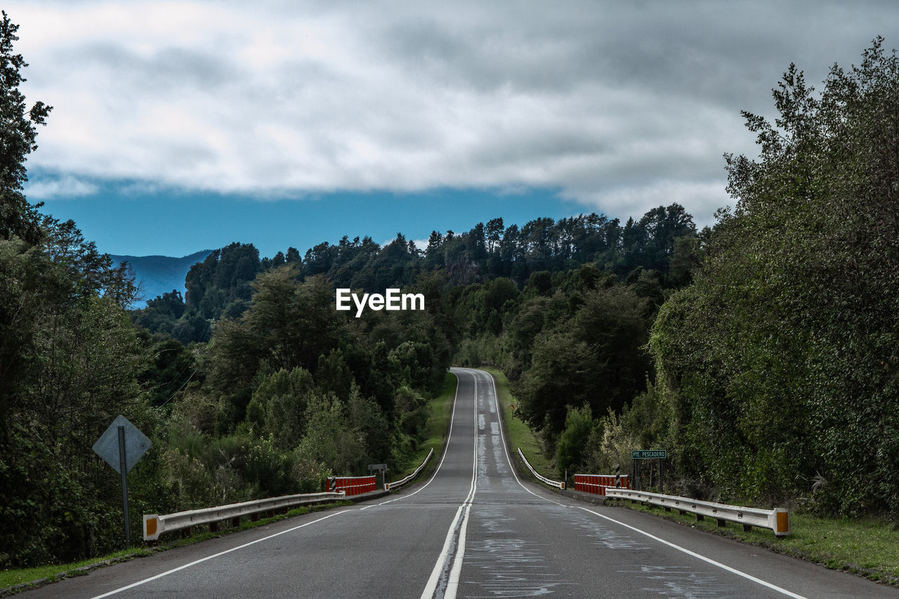 ROAD LEADING TOWARDS TREES AGAINST SKY