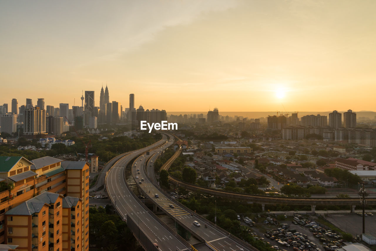 High angle view of bridges in city at sunset