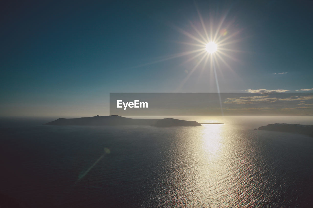 Scenic view of sea against blue sky on sunny day