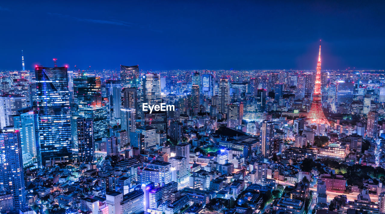 AERIAL VIEW OF ILLUMINATED CITY BUILDINGS AT NIGHT