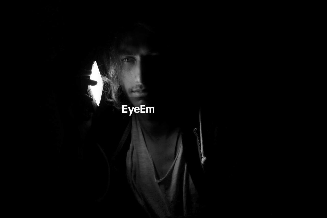 Close-up portrait of young man in darkroom