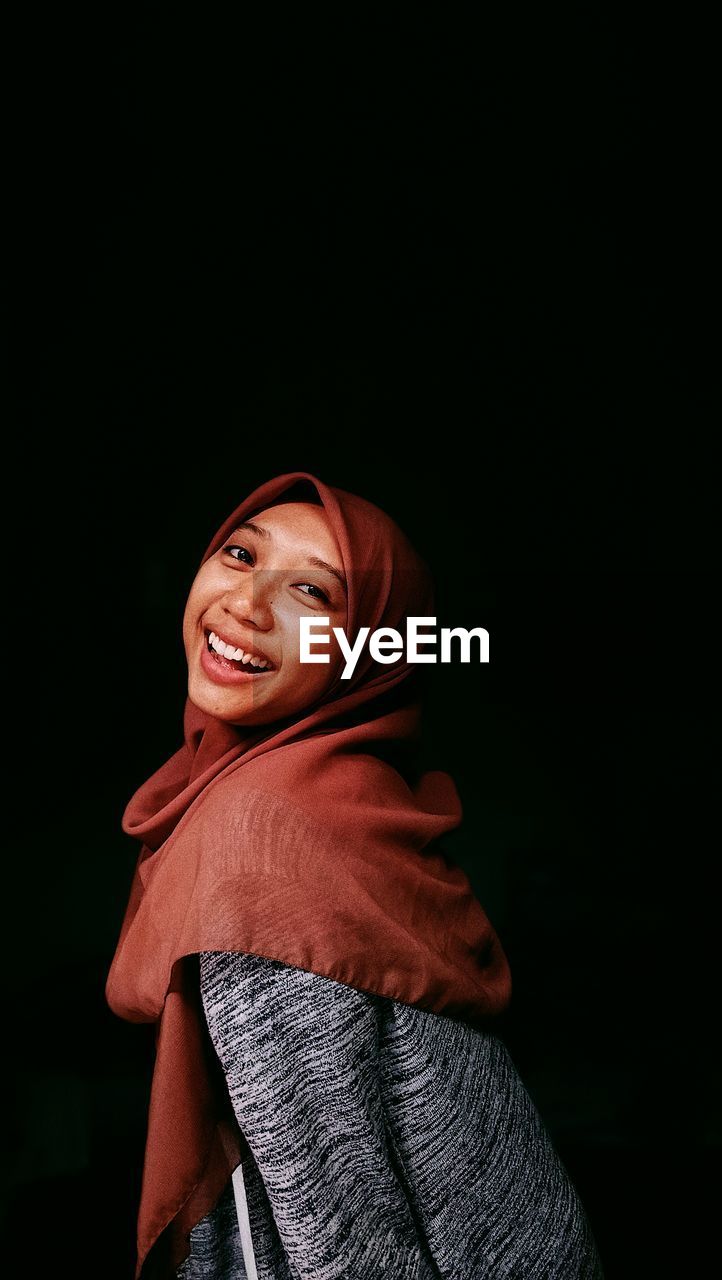 Woman standing against black background