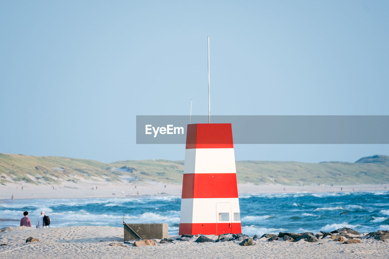 Lifeguard tower on beach against clear sky