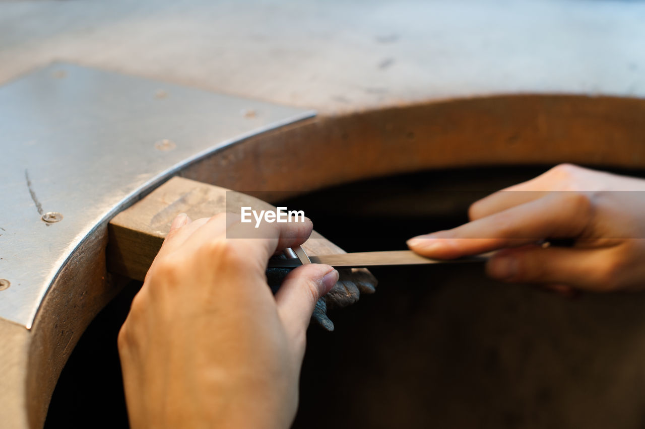 Cropped hands making wedding ring in workshop