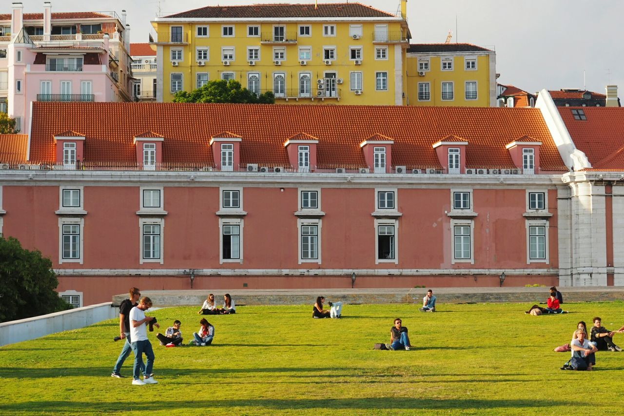 PEOPLE PLAYING IN FRONT OF BUILDINGS