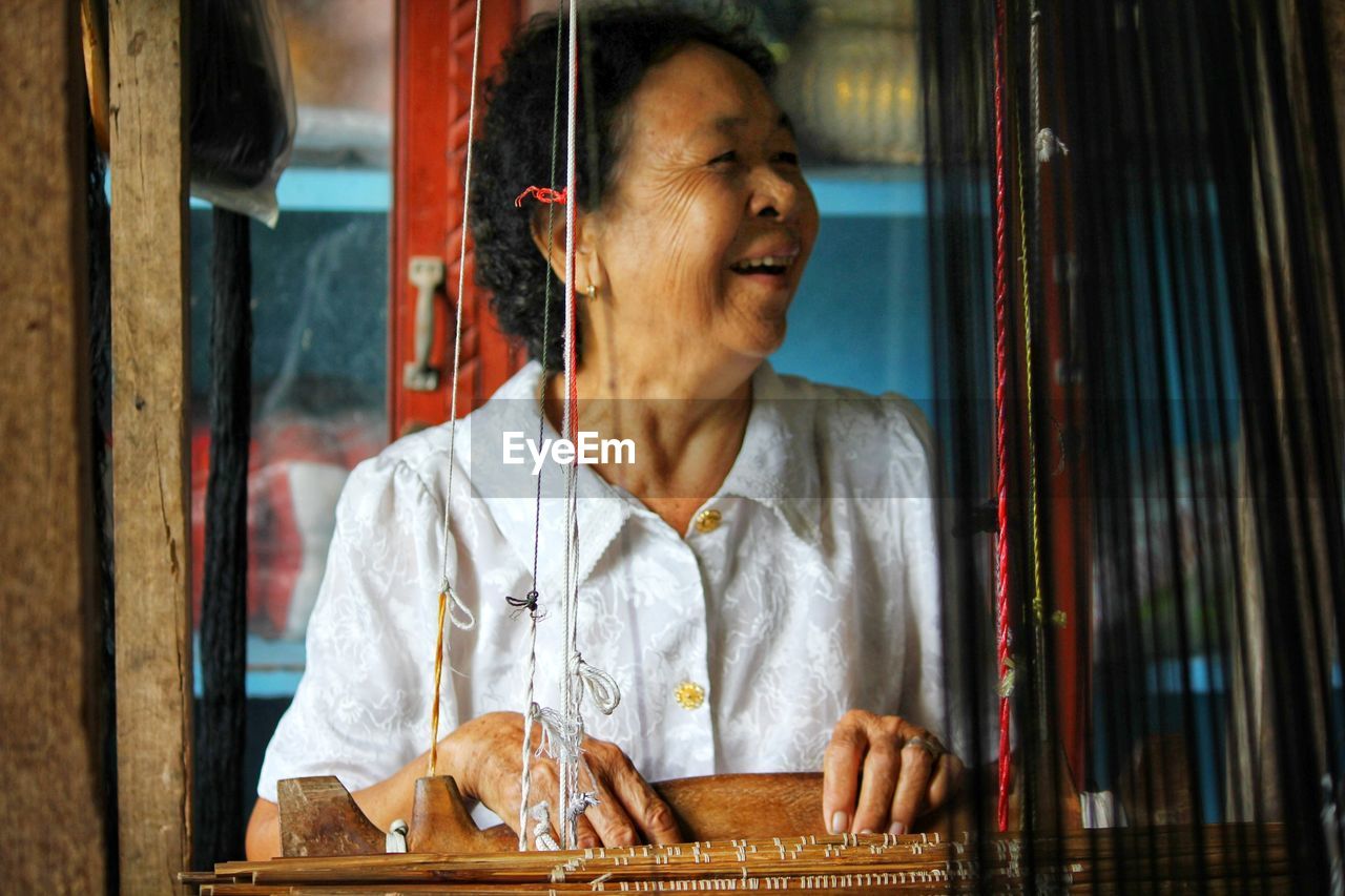 Grandma weaves cloth, seen in the provinces of thailand.