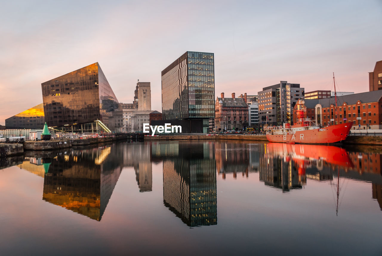 River with reflection against buildings in city