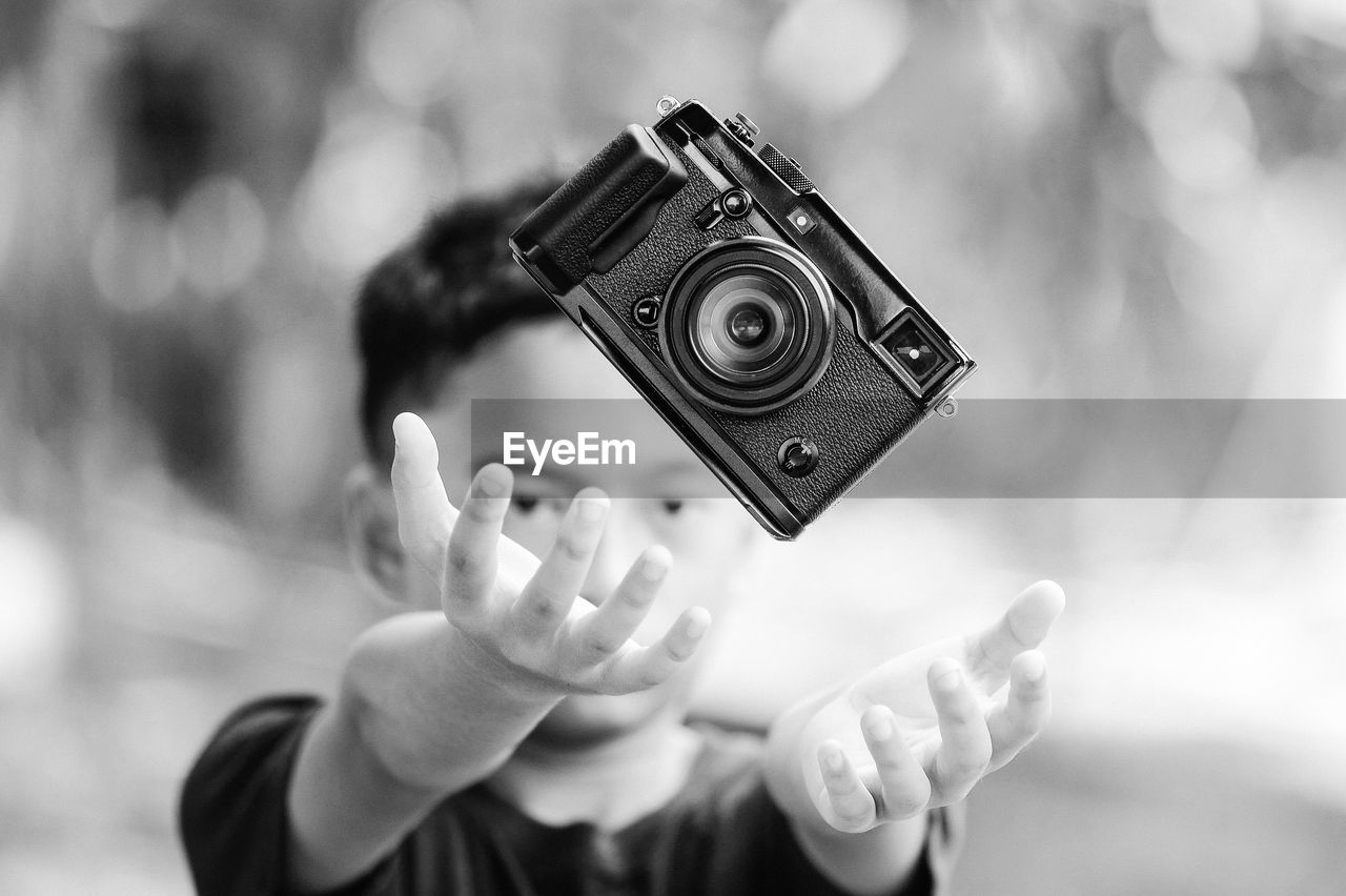 A boy doing a levitation with a digital camera