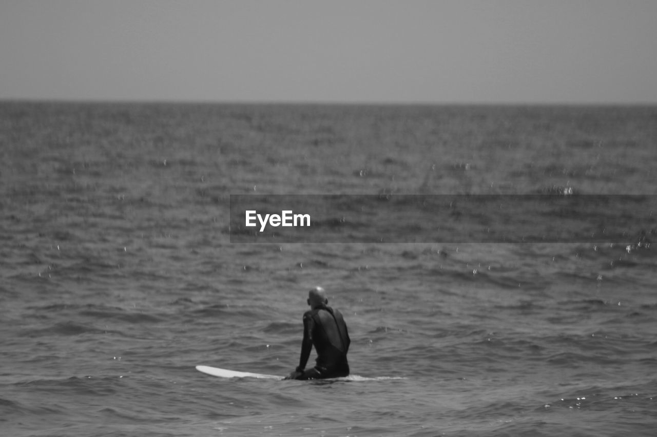 REAR VIEW OF MAN AT BEACH