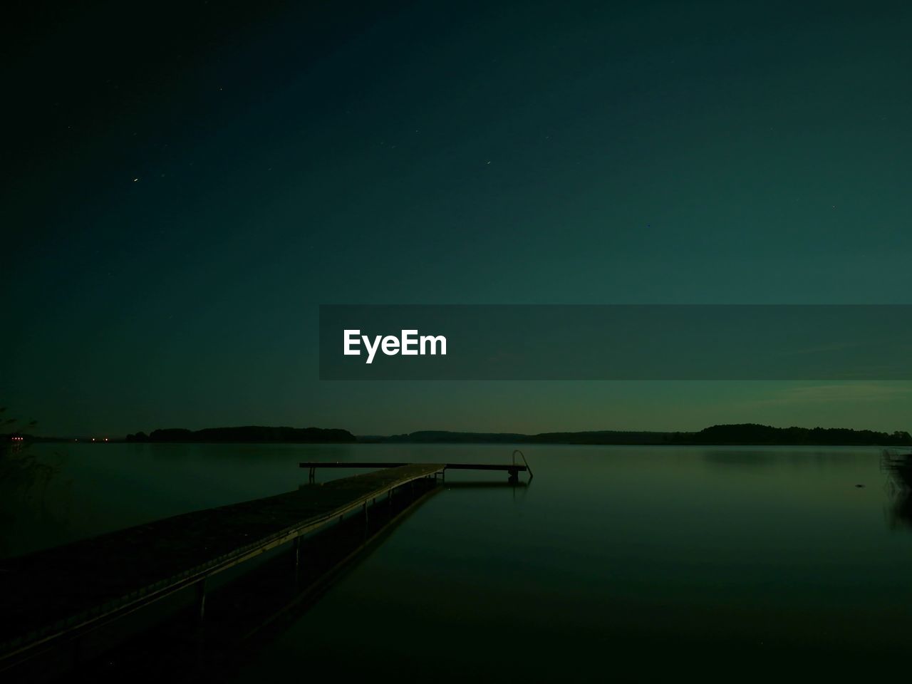 Scenic view of lake against sky at night