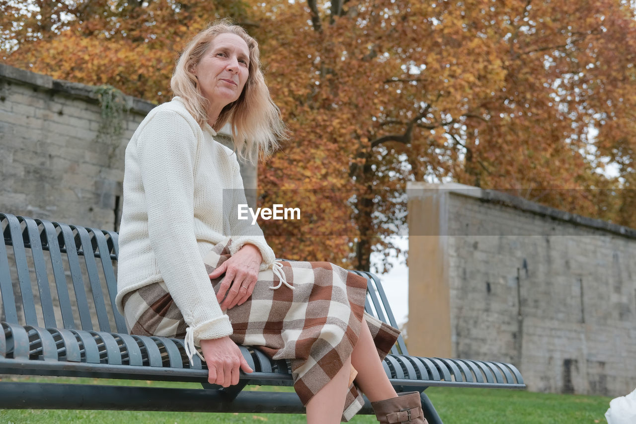 Woman sitting on bench in park