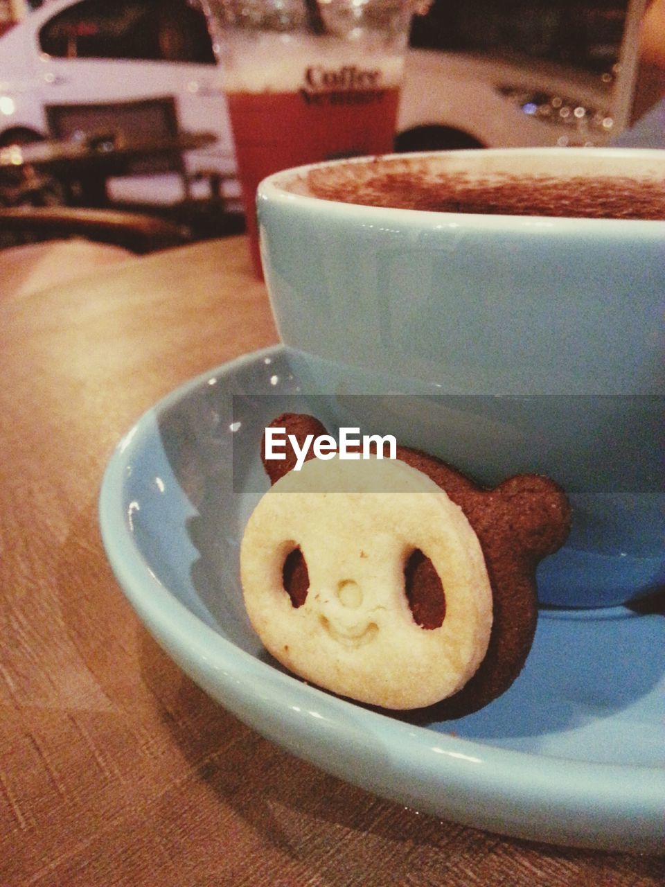 CLOSE-UP OF COFFEE CUP WITH SPOON AND DRINK ON TABLE