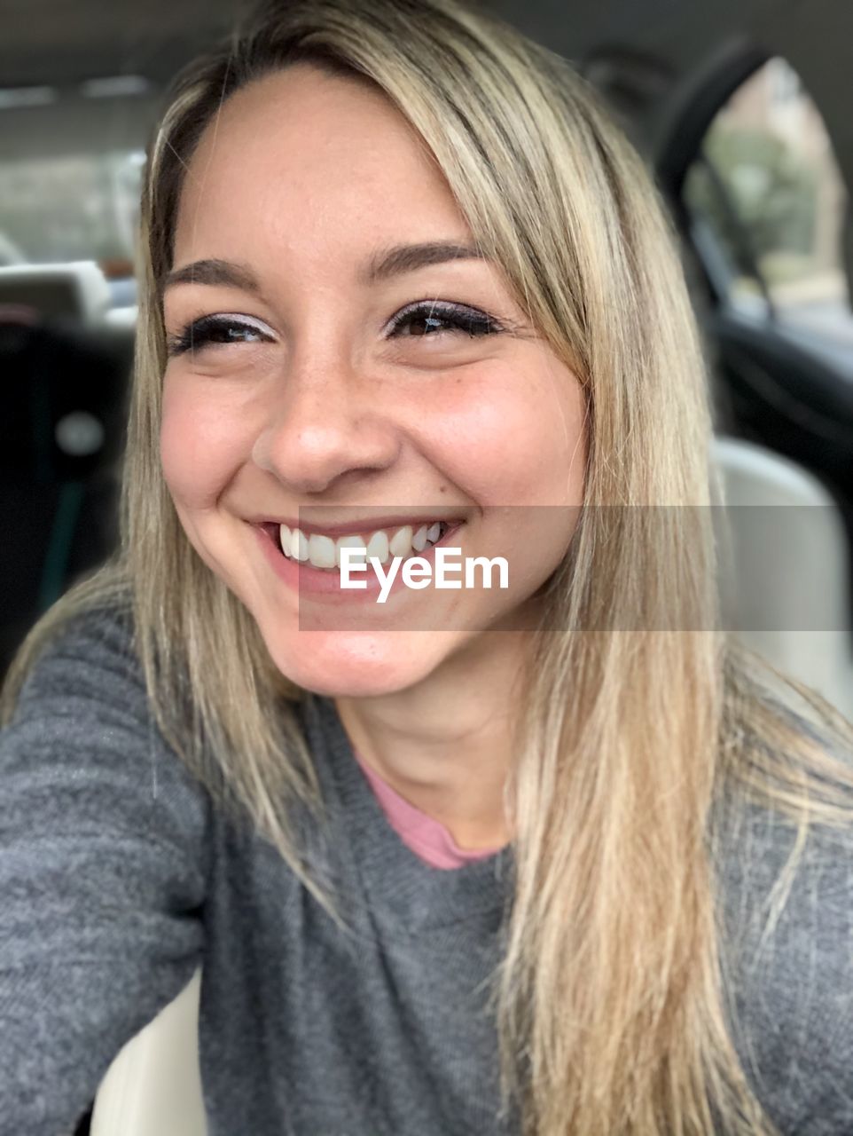 Portrait of smiling young woman in car