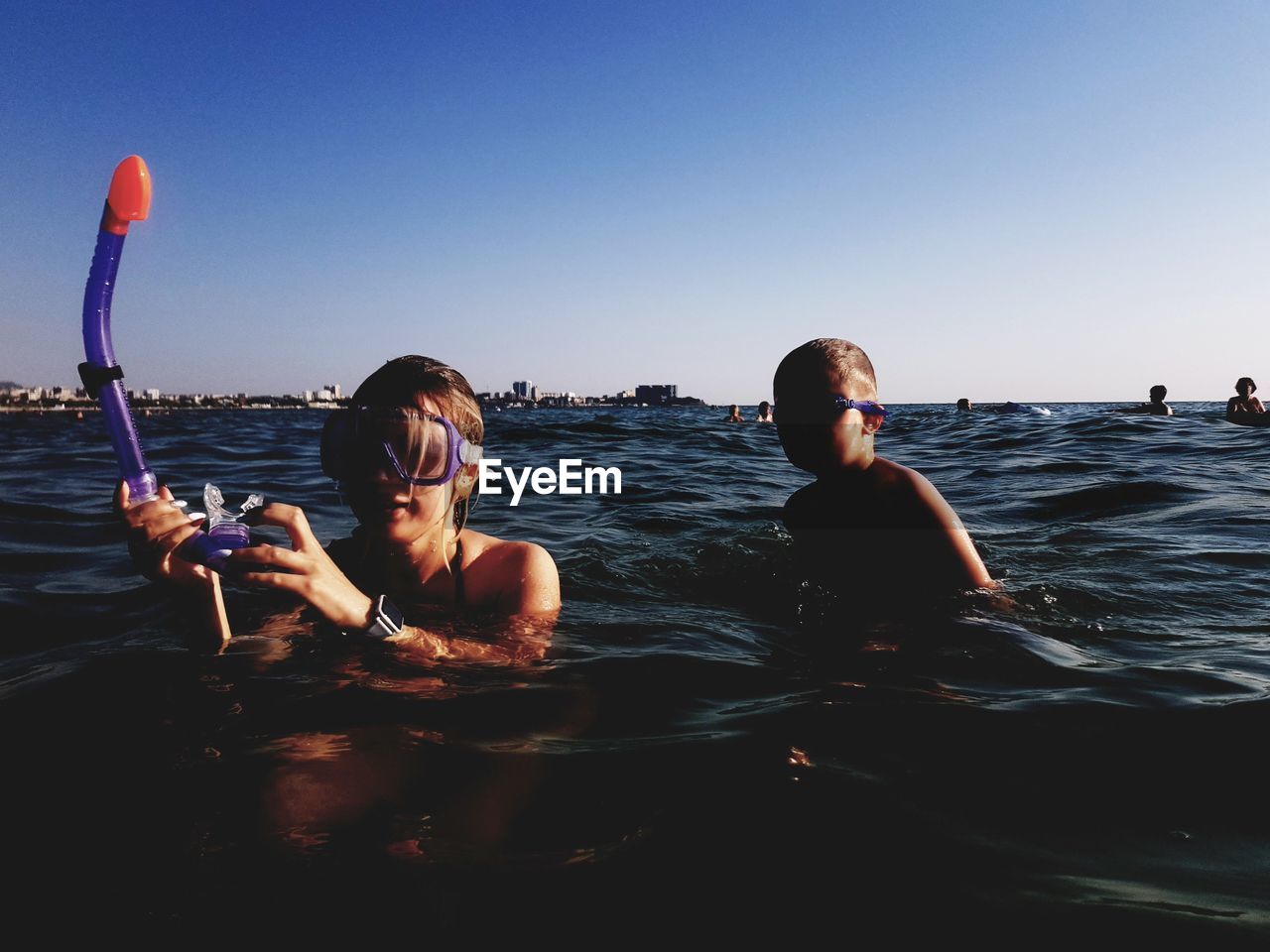 PORTRAIT OF FRIENDS ENJOYING IN SEA AGAINST SKY