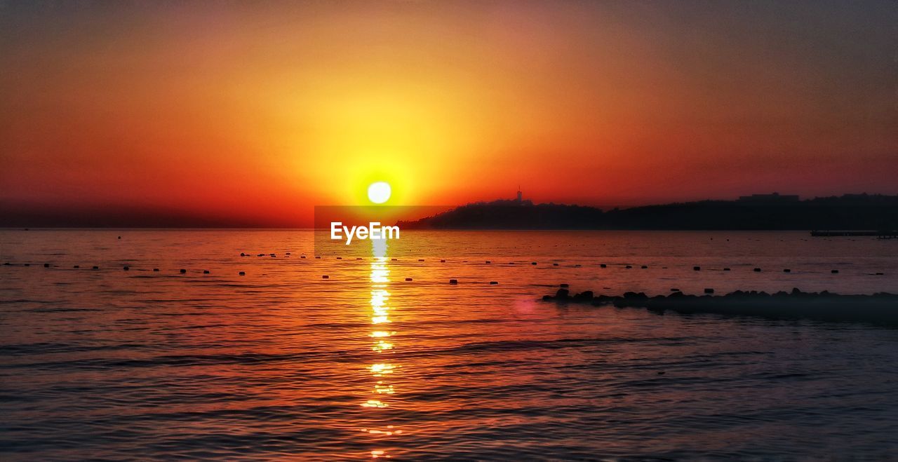 SCENIC VIEW OF SEA AGAINST SKY AT SUNSET