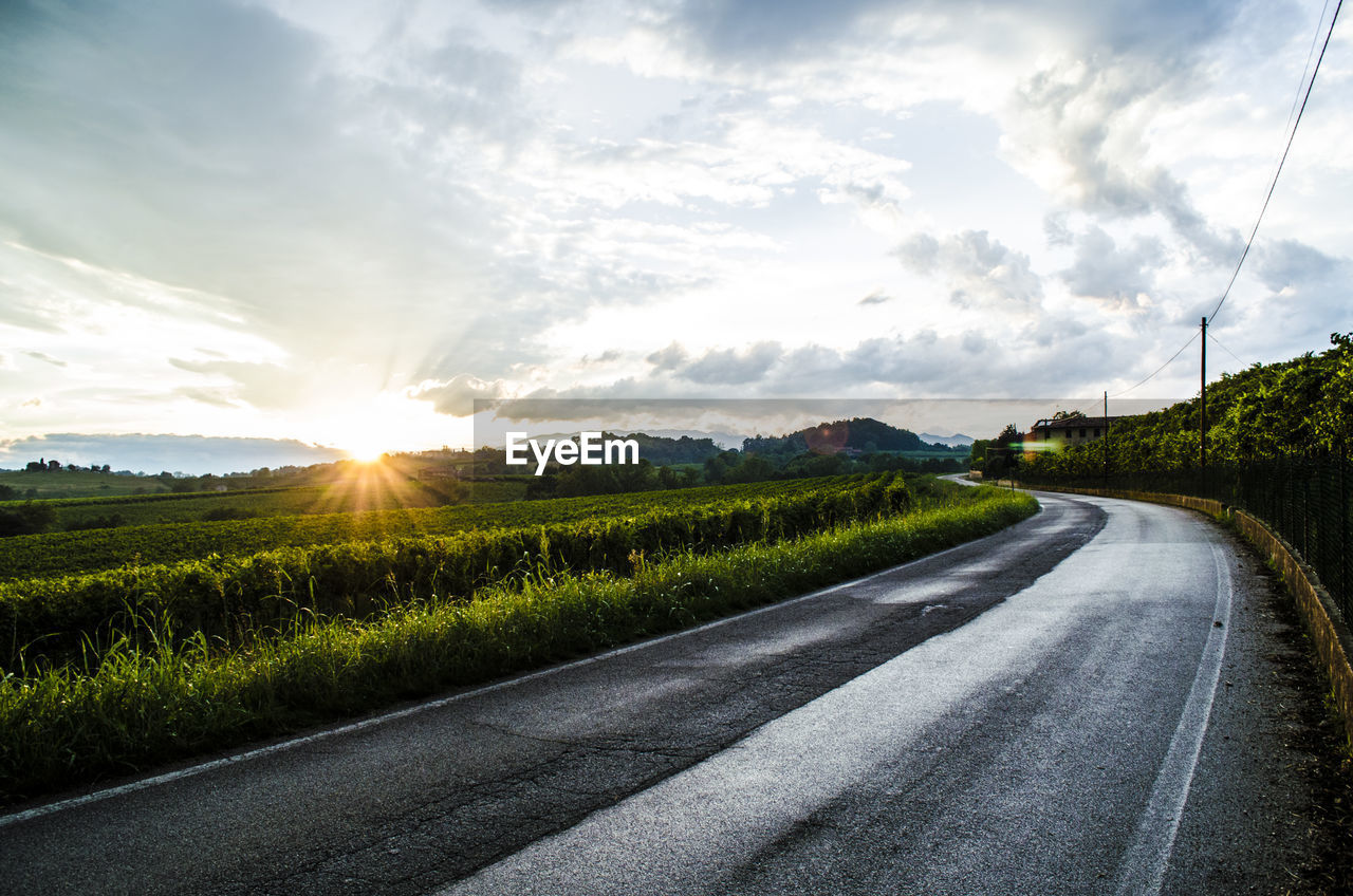 Road by landscape against sky