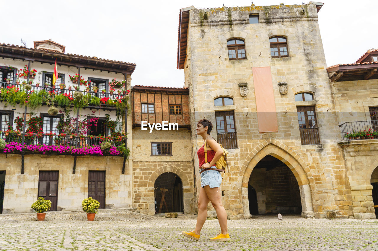 low section of woman standing in front of old building
