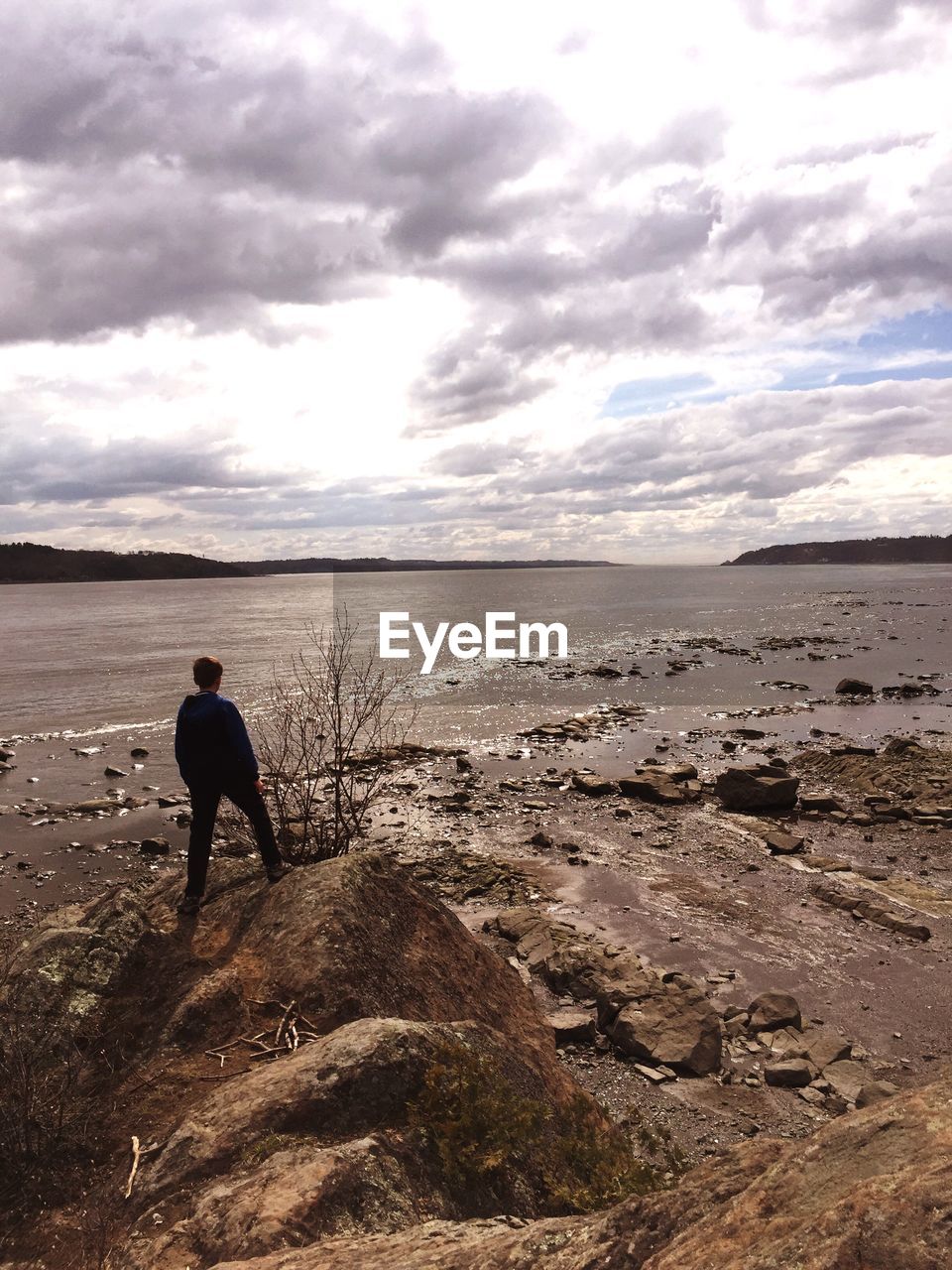 Man walking on shore against sky