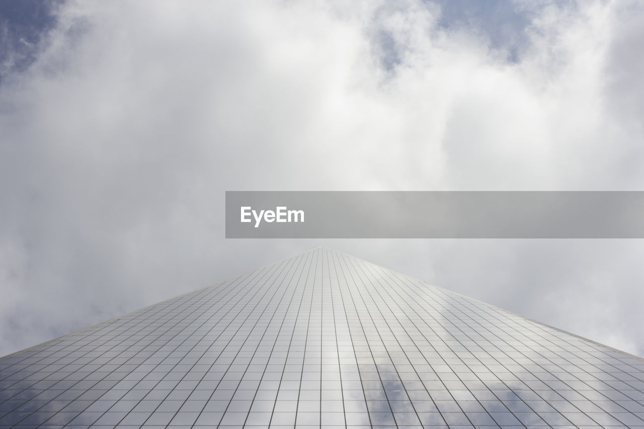 Low angle view of modern building against cloudy sky