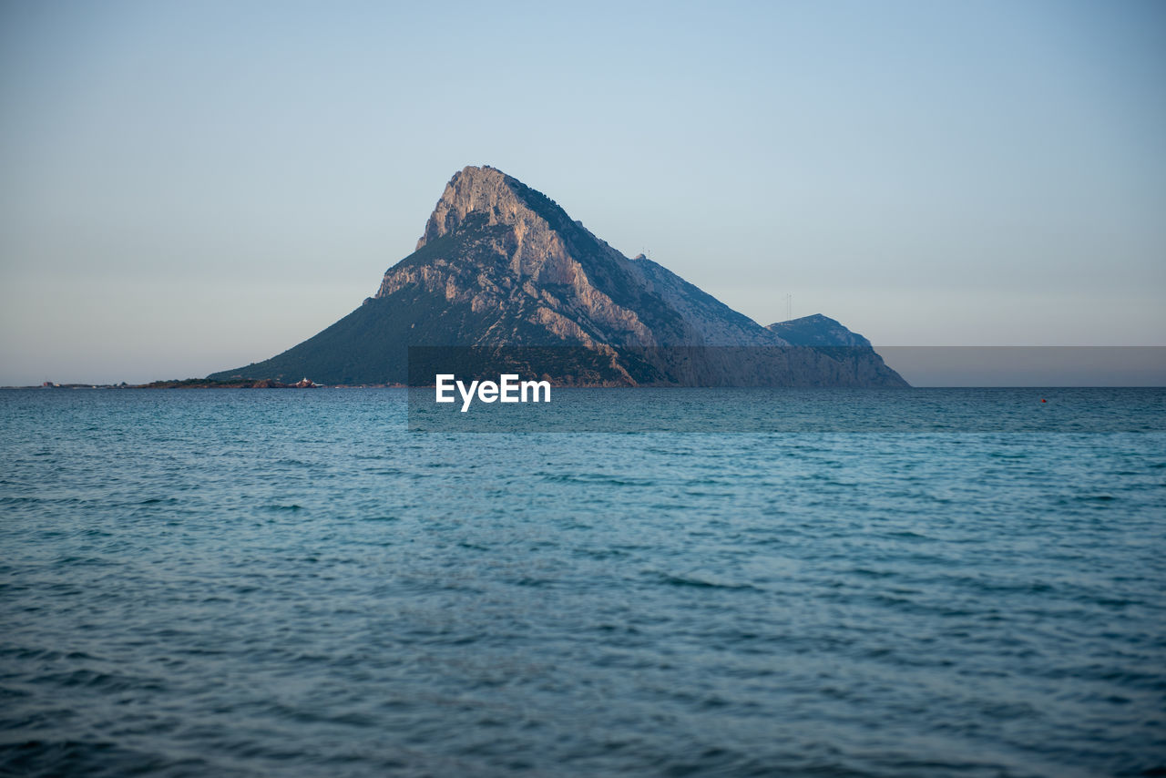 Scenic view of sea and mountains against clear sky