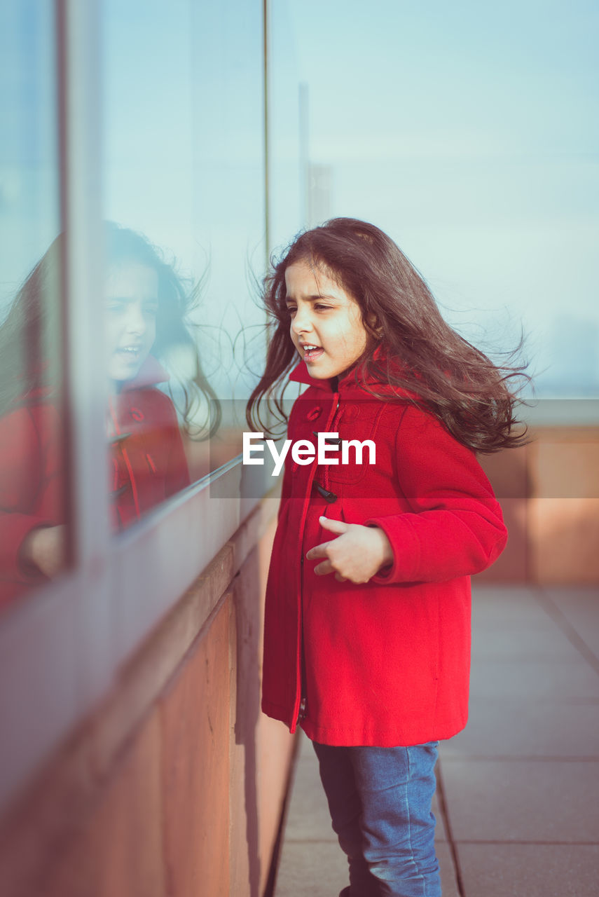 Girl standing by window