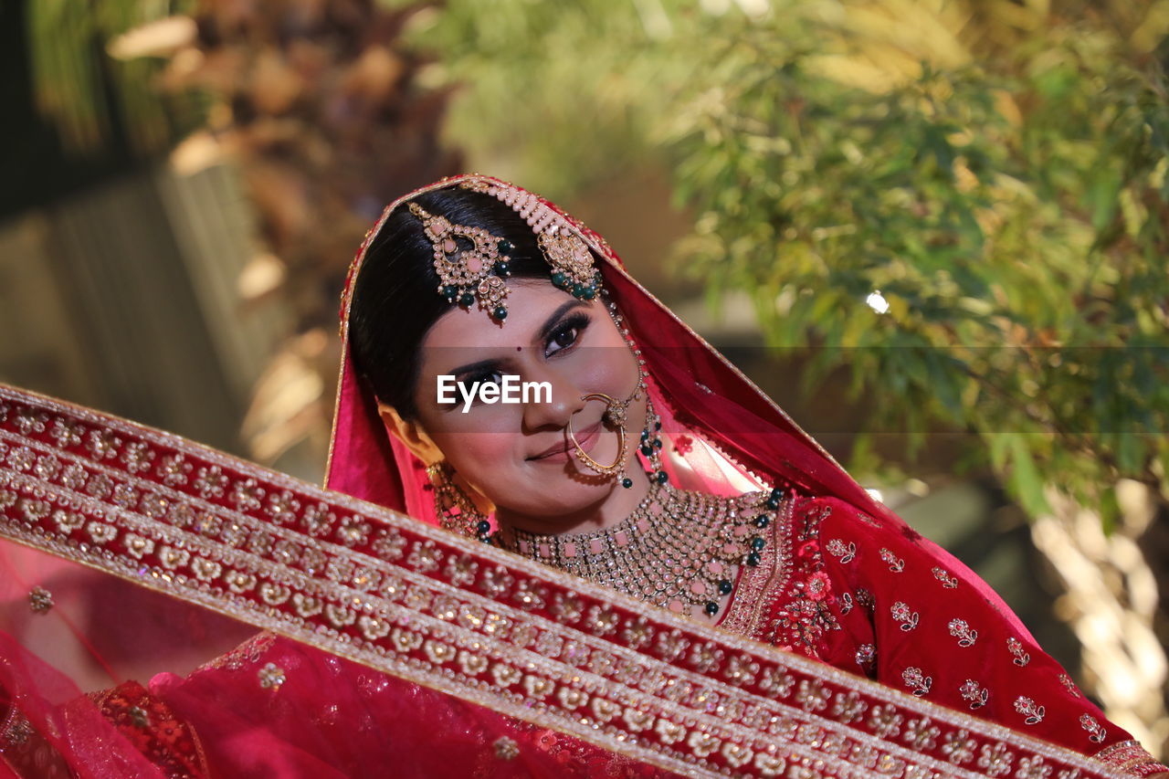 Portrait of smiling young woman in traditional clothing standing outdoors